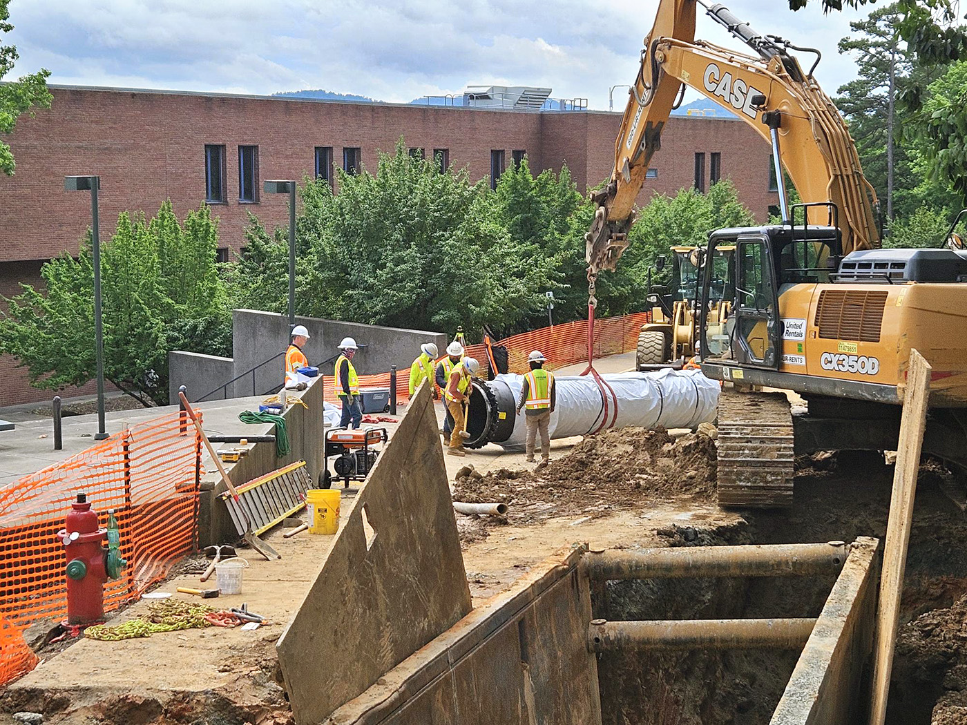 Excavation equipment lifting a pipe