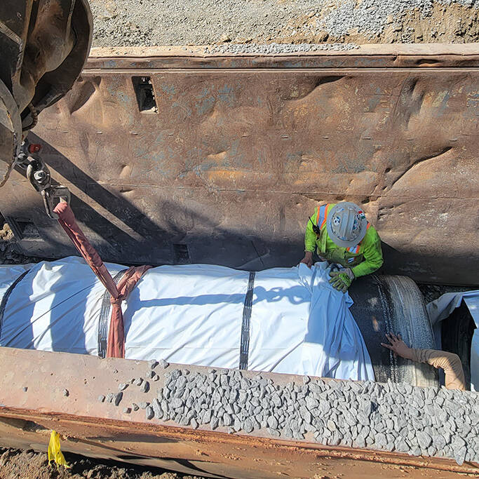 Construction Workers Installing Pipe